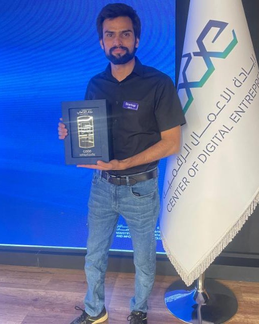 Kamran Khan holding an award